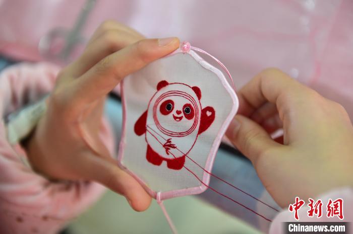 圖為一名小學(xué)生正在繡制2022年北京冬奧會吉祥物“冰墩墩”形象。 喻云亮 攝