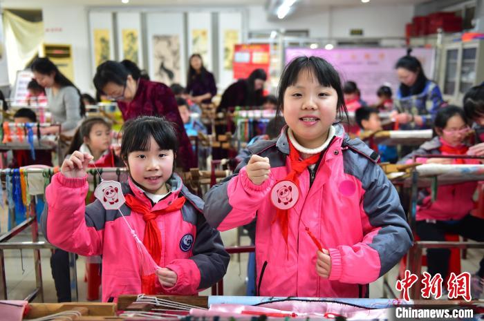 圖為小學(xué)生展示繡制好的2022年北京冬奧會吉祥物“冰墩墩”形象。 喻云亮 攝