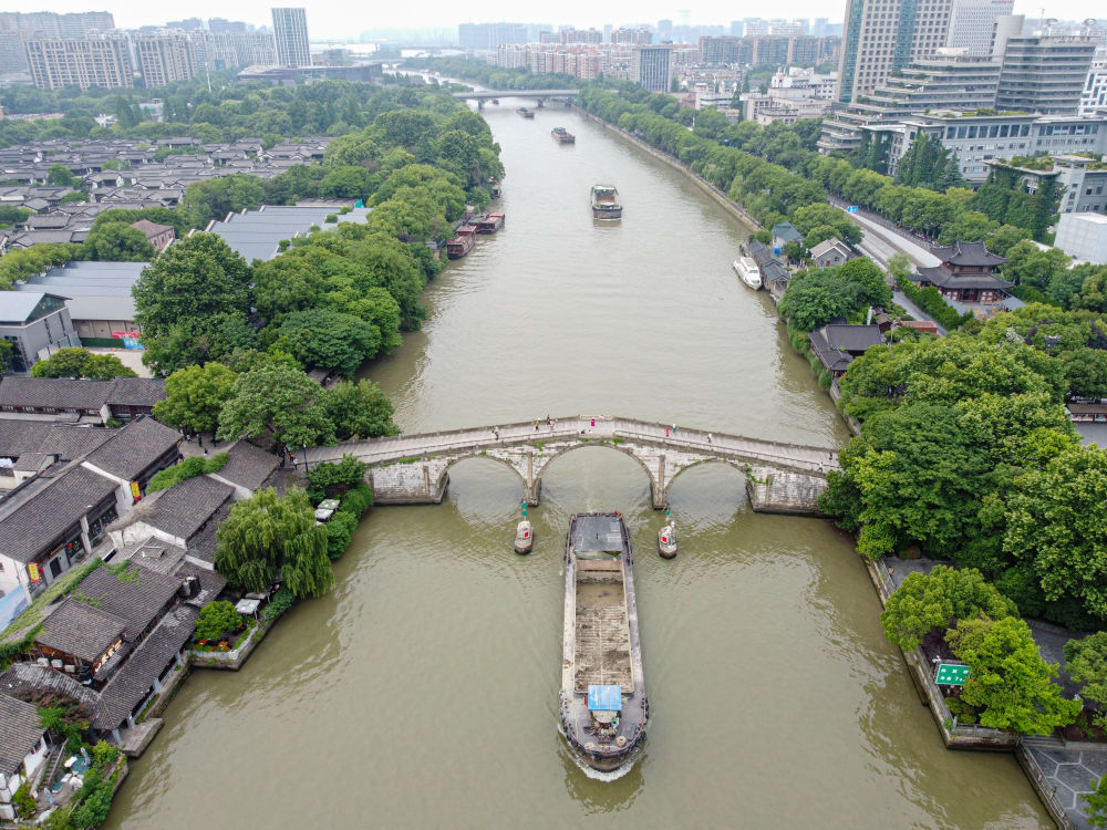 5月27日，一艘貨船駛過京杭大運河南端標志建筑杭州拱宸橋。(無人機照片)新華社記者江漢 攝
