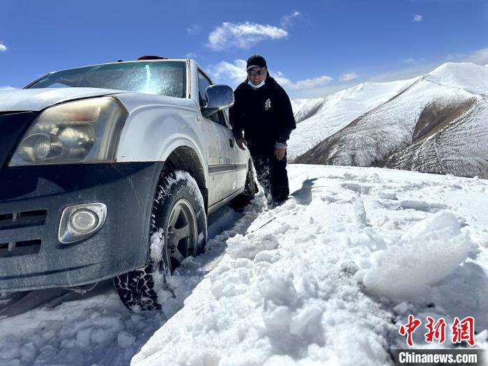 圖為生態(tài)管護人員準備在雪地推車?！《“瓦_杰 攝