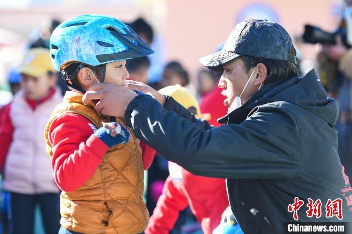 圖為拉薩市實驗幼兒園孩子在教練的幫助下穿戴頭盔。　何蓬磊 攝