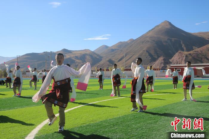 圖為青海師范大學(xué)附屬玉樹(shù)實(shí)驗(yàn)學(xué)校學(xué)生在綠茵場(chǎng)跳起囊謙古舞—卓根瑪。　程雨 攝