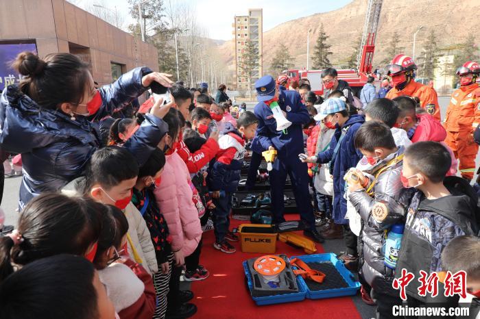 圖為小朋友們聽消防員講解消防器材。 楊龍建 攝