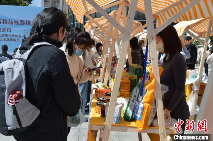 活動現(xiàn)場高校師生選購理塘農特產品?！≈炝杞?攝