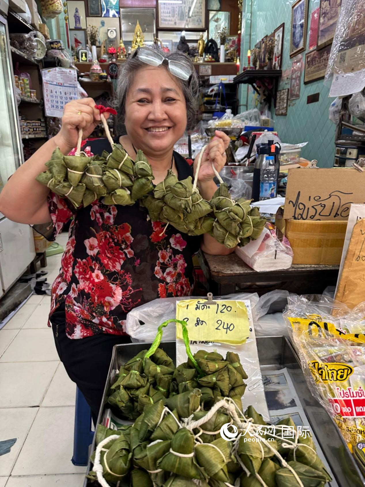 商家向顧客介紹“吉掌”（粽子的一種，一串一串，個(gè)頭較小）。人民網(wǎng)記者 簡(jiǎn)承淵攝