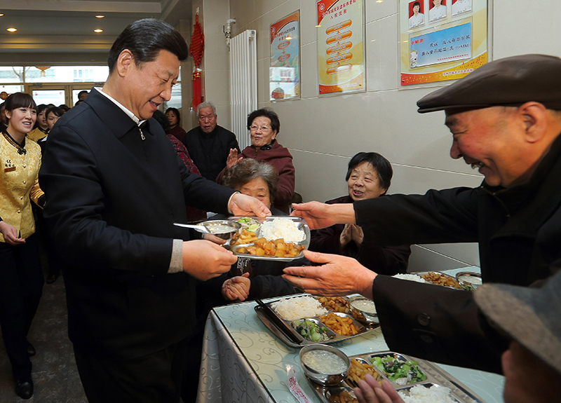 2013年2月4日，習近平總書記來到甘肅蘭州一家養老餐廳，端起一盤熱氣騰騰的飯菜，送到一位老人面前。