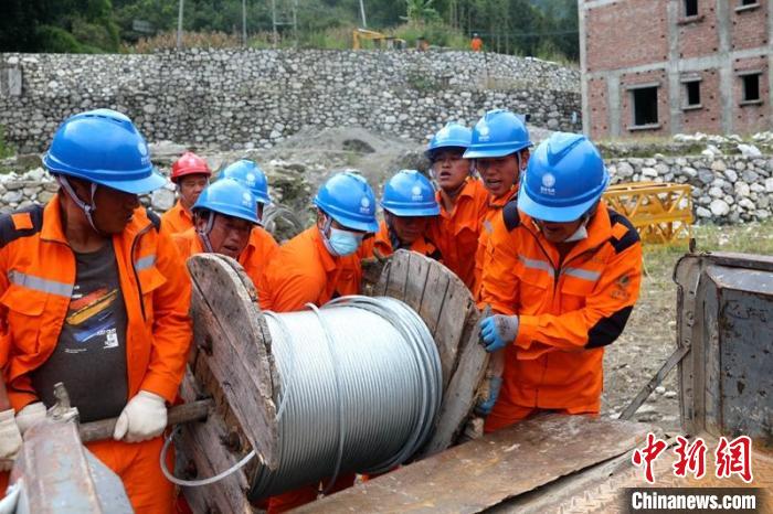 國網四川送變電公司搶險隊員將重達370公斤的鋼絞線搬上車。 劉湘釩 攝