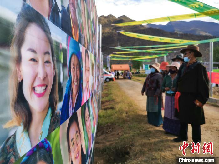 圖為當地民眾在觀看展板上的笑臉。　張偉 攝