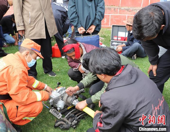 圖為森林消防員為護林員講解滅火裝備的使用方法?！〔际猩窒乐ш?供圖