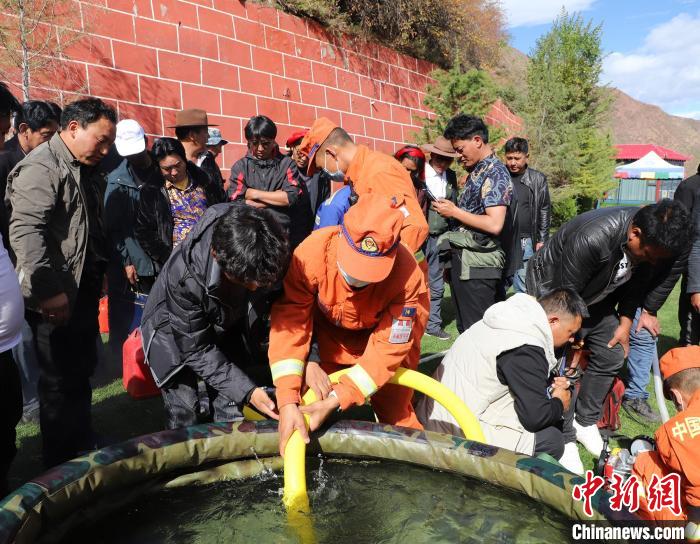 圖為森林消防員為護林員講解滅火裝備的使用方法。　昌都市森林消防支隊 供圖