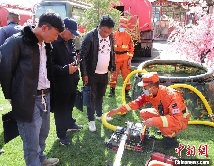 圖為森林消防員為護林員講解滅火裝備的使用方法。　昌都市森林消防支隊 供圖