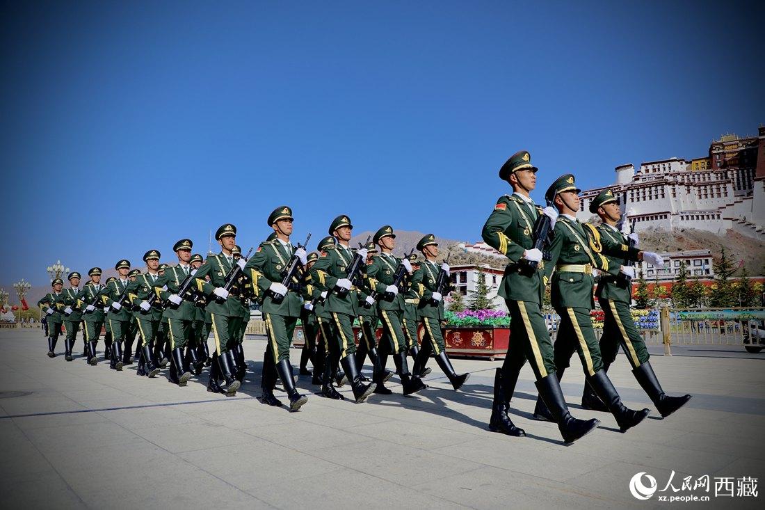 國(guó)旗護(hù)衛(wèi)隊(duì)隊(duì)員緊握鋼槍，踏著威武雄壯的步伐，走向國(guó)旗臺(tái)。人民網(wǎng) 次仁羅布攝