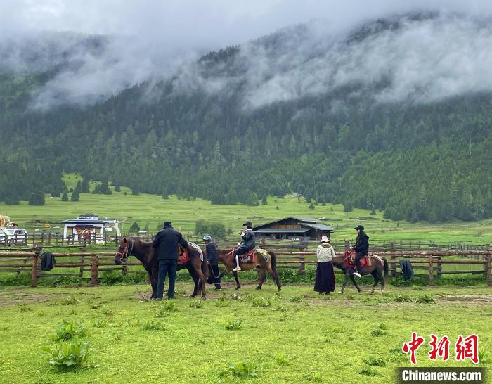 6月10日，游客在魯朗小鎮高山牧場景區體驗騎馬。　冉文娟 攝