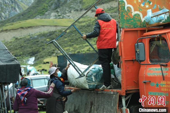 圖為工作人員幫助牧民們卸家具?！÷蹇?攝