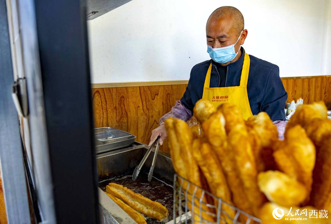 早餐店老板正在炸油條。人民網 次仁羅布攝