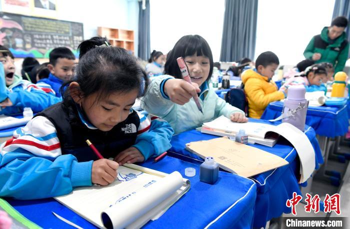 3月14日，西藏拉薩市第一小學一年級六班學生白瑪朗珍(圖左)在藏語文課上書寫藏文?！±盍?攝