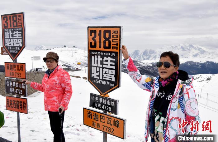 圖為5月14日，西藏林芝色季拉山觀景臺，游客與南迦巴瓦峰合影?！±盍?攝