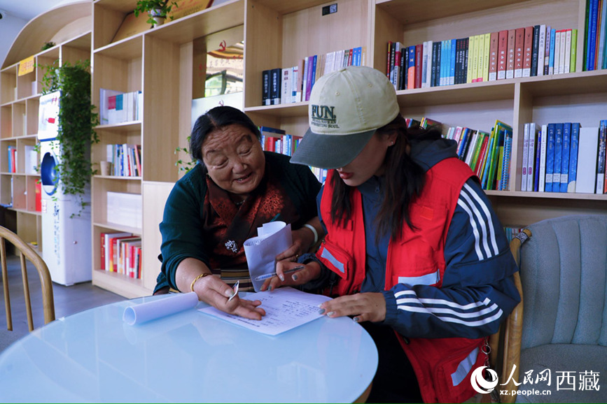 幸福社區的網格員協助老人填寫雙聯戶檔案表。人民網記者 次仁羅布攝