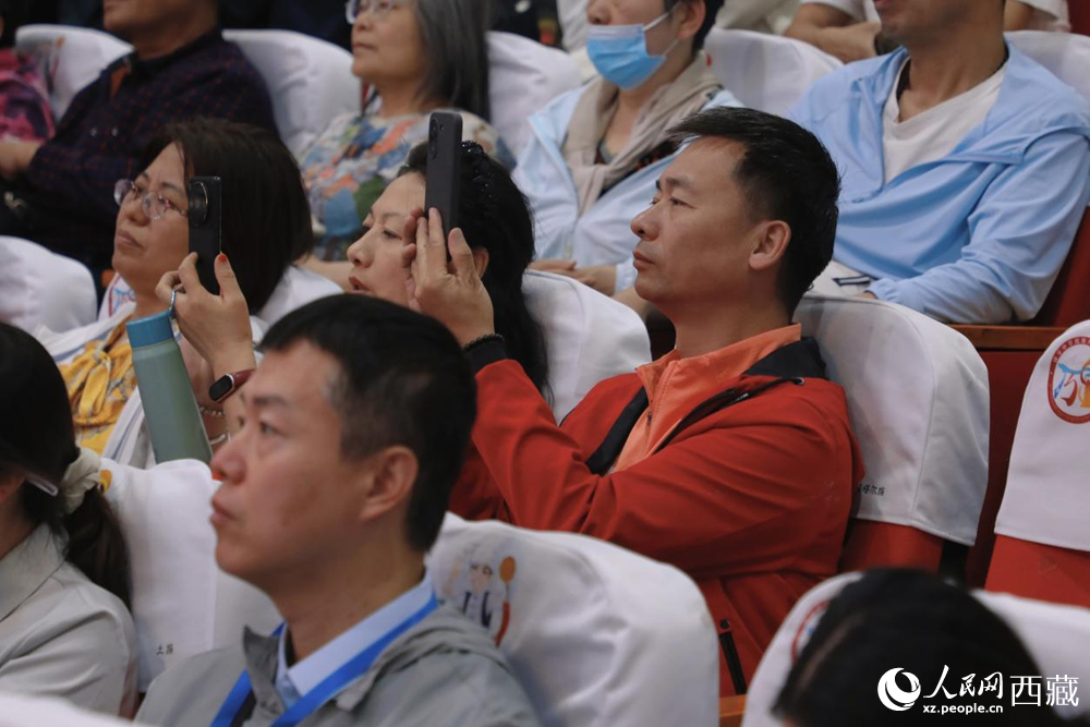 圖為游客用手機記錄精彩表演,沉浸于濃郁的文化體驗中。人民網記者 次仁羅布攝