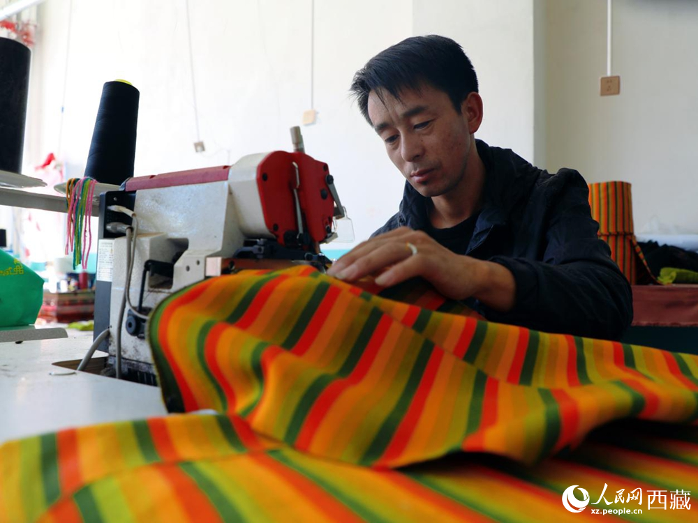 圖為工人操作機器編織氆氌。人民網記者 次仁羅布攝