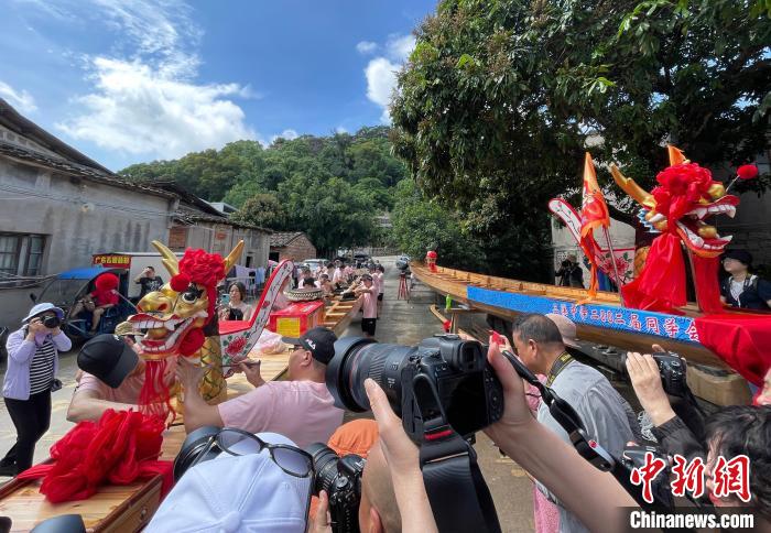 圖為5月29日,長樂江田鎮(zhèn)村民為即將入水的新龍舟安裝龍頭。 張斌 攝