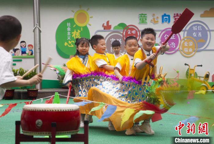 圖為龍舟賽游戲上，小伙伴們打鼓加油。　董觀生 攝